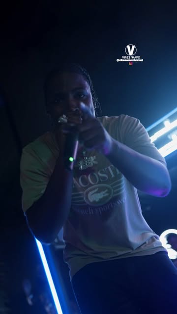 Live vocalist performing under blue and purple stage lights at a District event